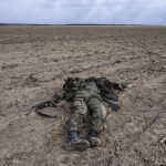 
              A Russian soldier killed during combats against Ukrainian army lies on a corn field in Sytnyaky, on the outskirts of Kyiv, Ukraine, Sunday, March 27, 2022. Ukrainian President Volodymyr Zelenskyy accused the West of lacking courage as his country fights to stave off Russia's invading troops, making an exasperated plea for fighter jets and tanks to sustain a defense in a conflict that has ground into a war of attrition. (AP Photo/Rodrigo Abd)
            