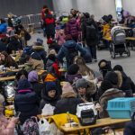 
              People wait in the reception center for refugees from Ukraine at the main train station in Berlin, Germany, Sunday, March 13, 20-22. (Hannibal Hanschke/dpa via AP)
            
