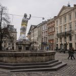 
              Pedestrians walk past a wrapped sculpture in Lviv's downtown, western Ukraine, Friday, March 4, 2022. Some of the monuments in Lviv are partially covered to lower the risk of damage in case of attacks in the city. (AP Photo/Bernat Armangue)
            