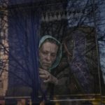 
              A woman waits on a bus for Ukrainian police to check papers and belongings in Brovary, Ukraine, Sunday, March 20, 2022, after 1600 people of which 843 children, according to authorities, were evacuated from the village of Bobrik, reportedly under Russian military control. Russian forces pushed deeper into Ukraine's besieged and battered port city of Mariupol on Saturday, where heavy fighting shut down a major steel plant and local authorities pleaded for more Western help. (AP Photo/Vadim Ghirda)
            