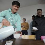 
              Host Christian Vollmann, left, serves tea to Deborah Samuel, second left, Shalom Odion, second right, and Kurrah David after an interview with The Associated press in Gross Koeris near Berlin, Germany, Monday, March 7, 2022. Vollmann offered his holiday home until the end of April to the Nigerian students who fled Kyiv after the Russian attack on Ukraine. (AP Photo/Michael Sohn)
            