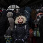 
              FILE - A girl catches snowflakes as she waits with others to board a train to Poland, at Lviv railway station, Sunday, Feb. 27, 2022, in Lviv, west Ukraine. The United Nations says that more than 3.6 million people have fled Ukraine since the war started exactly one month ago Thursday in what is the biggest movement of people in Europe since World War II. Unprepared, most refugees believed they would soon be back home. That hope is waning now. (AP Photo/Bernat Armangue, File)
            