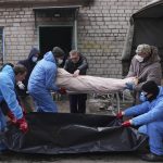 
              Mortuary's workers move a dead body into a plastic bag in outskirts of Mariupol, Ukraine, Wednesday, March 9, 2022. (AP Photo/Evgeniy Maloletka)
            