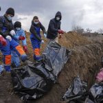 
              Dead bodies are placed into a mass grave on the outskirts of Mariupol, Ukraine, Wednesday, March 9, 2022 as people cannot bury their dead because of the heavy shelling by Russian forces. (AP Photo/Evgeniy Maloletka)
            