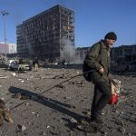 
              A man walks with his dog amid the destruction caused after shelling of a shopping center, in Kyiv, Ukraine, Monday, March 21, 2022. (AP Photo/ (AP Photo/Rodrigo Abd)
            
