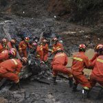 
              In this photo released by Xinhua News Agency, search and rescue workers pull debris out from the mud at the China Eastern flight crash site in Tengxian County in southern China's Guangxi Zhuang Autonomous Region on Thursday, March 24, 2022. Hundreds of people in rain gear and rubber boots searched muddy, forested hills in southern China on Thursday for the second flight recorder from a jetliner that crashed with 132 people aboard. (Lu Boan/Xinhua via AP)
            