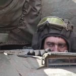 
              A Ukrainian serviceman looks out from a tank in the village of Lukyanivka, Kyiv region, Ukraine, Sunday, March 27, 2022. (AP Photo)
            