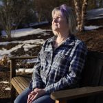 
              Lynn Wencus, of Wrentham, Mass., sits on a bench placed in her garden in remembrance of her son Jeff at her home, in Wrentham, Wednesday, March 2, 2022. Wencus lost her son to a heroin overdose in 2017. OxyContin maker Purdue Pharma and virtually all U.S. states have agreed to a new settlement of opioid lawsuits. The deal reached Thursday, March 3, 2022, would require members of the Sackler family who own the drugmaker to pay $5.5 billion to $6 billion in cash. They also apologized. A bankruptcy judge must still approve the deal. (AP Photo/Steven Senne)
            
