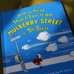 
              FILE - A copy of the book "And to Think That I Saw It on Mulberry Street," by Dr. Seuss, rests in a chair, Monday, March 1, 2021, in Walpole, Mass. A year after ceasing publication of six Dr. Seuss books, including "And to Think That I Saw It on Mulberry Street," because of racist and insensitive imagery, the company that preserves the late author's legacy says it's launching a new effort to work with an "inclusive community of new and emerging authors and illustrators" to create original stories inspired by unpublished Seuss sketches. (AP Photo/Steven Senne, File)
            