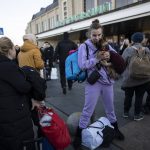 
              Daryna Kovalenko, 19 , holds her dog Tim, while arriving at Kyiv's train station after leaving her home in Chernihiv, Ukraine, through a humanitarian corridor, Monday, March 21, 2022. (AP Photo/ (AP Photo/Rodrigo Abd)
            