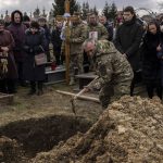 
              Relatives and friends attend the funeral of senior police sergeant Roman Rushchyshyn in the village of Soposhyn, outskirts of Lviv, western Ukraine, Thursday, March 10, 2022, in Lviv. Rushchyshyn, a member of the Lviv Special Police Patrol Battalion, was killed in the Luhansk Region. Temporary cease-fires to allow evacuations and humanitarian aid have repeatedly faltered, with Ukraine accusing Russia of continuing its bombardments. (AP Photo/Bernat Armangue)
            