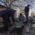 
              Men cook a meal in a street in Mariupol, Ukraine, Sunday, March 13, 2022. The surrounded southern city of Mariupol, where the war has produced some of the greatest human suffering, remained cut off despite earlier talks on creating aid or evacuation convoys. (AP Photo/Evgeniy Maloletka)
            