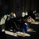 
              A Ukrainian sitting man in a wheel chair, waits with other refugees at Przemysl train station, southeastern Poland, on Friday, March 11, 2022. Thousands of people have been killed and more than 2.3 million have fled the country since Russian troops crossed into Ukraine on Feb. 24. (AP Photo/Daniel Cole)
            