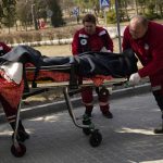 
              An injured man is wheeled on a stretcher at a local hospital in Novoiavorisk, western Ukraine, Sunday, March 13, 2022. Local officials in western Ukraine say a Russian airstrike has hit a military training base that has hosted NATO drills. (AP Photo/Bernat Armangue)
            