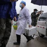 
              Medical workers arrive for duty near the crash site on Wednesday, March 23, 2022, Lu village, in southwestern China's Guangxi province. The search for clues into why a plane made an inexplicable dive and crashed into a mountain in southern China was suspended Wednesday as rain slicked the debris field and filled the red-dirt gash formed by the plane's fiery impact. (AP Photo/Ng Han Guan)
            