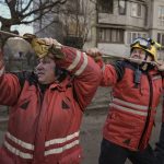 
              Firefighters pull a rope to direct the fall of a tree while working to extinguish a blaze in a destroyed apartment building after a bombing in a residential area in Kyiv, Ukraine, Tuesday, March 15, 2022. Russia's offensive in Ukraine has edged closer to central Kyiv with a series of strikes hitting a residential neighborhood as the leaders of three European Union member countries planned a visit to Ukraine's embattled capital. (AP Photo/Vadim Ghirda)
            