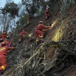 
              In this photo released by Xinhua News Agency, rescuers conduct search operations at the site of a plane crash in Tengxian County in southern China's Guangxi Zhuang Autonomous Region, Tuesday, March 22, 2022. Mud-stained wallets. Bank cards. Official identity cards. Some of the personal effects of 132 lives presumed lost were lined up by rescue workers scouring a remote mountainside Tuesday for the wreckage of a China Eastern plane that one day earlier inexplicably fell from the sky and burst into a huge fireball. (Zhou Hua/Xinhua via AP)
            