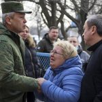 
              Eduard Basurin, deputy head of the People's Militia of the Donetsk People's Republic, left, tries to reassure the resident of the building affected by the shelling in Donetsk, on the territory which is under the Government of the Donetsk People's Republic control, eastern Ukraine, Wednesday, March 30, 2022. (AP Photo/Alexei Alexandrov)
            