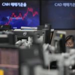 
              A currency trader watches computer monitors near the screens at a foreign exchange dealing room in Seoul, South Korea, Wednesday, March 23, 2022. Asian shares rose Wednesday, following a rally on Wall Street led by technology companies, although investors remain concerned about the war in Ukraine and inflation. (AP Photo/Lee Jin-man)
            