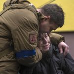 
              A soldier comforts Larysa Kolesnyk, 82, after she was evacuated from Irpin, on the outskirts of Kyiv, Ukraine, Wednesday, March 30, 2022. (AP Photo/Rodrigo Abd)
            
