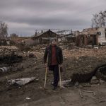 
              A resident stands next to parts of a destroyed Russian tank in the town of Trostsyanets, Ukraine, Monday, March 28, 2022. Trostsyanets was recently retaken by Ukrainian forces after being held by Russians since the early days of the war. (AP Photo/Felipe Dana)
            