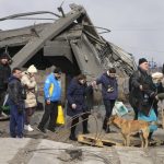 
              Ukrainians cross an improvised path under a destroyed bridge while fleeing Irpin, northwest of Kyiv, Saturday, March 12, 2022. Kyiv northwest suburbs such as Irpin and Bucha have been enduring Russian shellfire and bombardments for over a week prompting residents to leave their home. (AP Photo/Efrem Lukatsky)
            