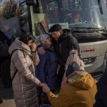 
              Ukrainian families say goodbye as they prepare to board a bus to Poland at Lviv bus main station, western Ukraine, Tuesday, March 1, 2022. Russian shelling pounded civilian targets in Ukraine's second-largest city Tuesday and a 40-mile convoy of tanks and other vehicles threatened the capital — tactics Ukraine’s embattled president said were designed to force him into concessions in Europe’s largest ground war in generations. (AP Photo/Bernat Armangue)
            