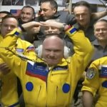 
              In this photo taken from video footage released by the Roscosmos Space Agency, newly arrived to the ISS, wearing yellow suits, Russian cosmonauts Оleg Аrtemiev, center, Denis Мatveev, right, and Sergei Korsakov pose among other participants of expedition to the International Space Station, ISS, after docking the Soyuz MS-21 spaceship to the station, Friday, March 18, 2022. (Roscosmos Space Agency via AP)
            