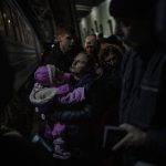 
              Displaced Ukrainians wait to board a Poland bound train in Lviv, western Ukraine, Sunday, March 13, 2022. Lviv in western Ukraine itself so far has been spared the scale of destruction unfolding to its east and south. The city's population of 721,000 has swelled during the war with residents escaping bombarded population centers and as a waystation for the nearly 2.6 million people who have fled the country. (AP Photo/Bernat Armangue)
            