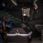 
              Oksana weeps next to a coffin containing the body of her husband Volodymyr Nezhenets, 54, during his funeral in the city of Kyiv, Ukraine, Friday, March 4, 2022. A small group of reservists are burying their comrade, 54-year-old Volodymyr Nezhenets, who was one of three killed on Feb. 26 in an ambush Ukrainian authorities say was caused by Russian 'saboteurs'. (AP Photo/Emilio Morenatti)
            