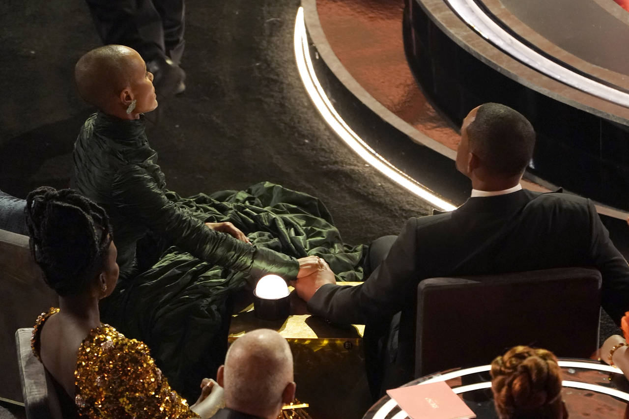 FILE - Jada Pinkett Smith, left, and Will Smith hold hands in the audience at the Oscars on March 2...