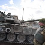 
              A Ukrainian serviceman stands next to a tank in a village of Lukyanivka, Kyiv region, Ukraine, Sunday, March 27, 2022. (AP Photo)
            