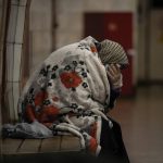 
              An elderly woman sits on a bench wrapped in a blanket in a subway station turned into a shelter in Kyiv, Ukraine, Tuesday, March 8, 2022. (AP Photo/Vadim Ghirda)
            