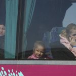 
              Refugees look out from a bus after fleeing the war from neighbouring Ukraine, at the border crossing in Palanca, Moldova, Saturday, March 19, 2022. (AP Photo/Sergei Grits)
            