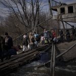 
              Ukrainians cross an improvised path under a destroyed bridge while fleeing Irpin, on the outskirts of Kyiv, Ukraine, Wednesday, March 9, 2022. (AP Photo/Felipe Dana)
            