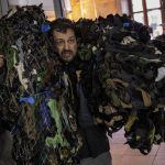 
              A Ukrainian volunteer carries camouflage nets at a distribution center in Lviv, western Ukraine, Wednesday, March 2, 2022. Russia renewed its assault Wednesday on Ukraine’s second-largest city in a pounding that lit up the skyline with balls of fire over populated areas, even as Moscow said it would be ready to resume talks aimed at stopping the new devastating war in Europe. (AP Photo/Bernat Armangue)
            