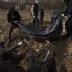 
              Dead bodies are placed into a mass grave at a cemetery in Kharkiv, Ukraine, Saturday, March 26, 2022. According to workers, most of them died of natural causes and were buried in the mass grave after no relatives claimed the bodies. (AP Photo/Felipe Dana)
            