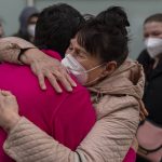 
              Displaced Ukrainians hug after arriving by bus at the Hospital Zendal in Madrid, Spain, Wednesday, March 16, 2022. (AP Photo/Manu Fernandez)
            