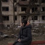 
              A resident sits outside a destroyed building after it was hit by artillery shelling in Kyiv in Kyiv, Ukraine, Monday, March 14, 2022. (AP Photo/Felipe Dana)
            