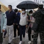 
              Relatives of passengers onboard the China Eastern Flight 5735 arrive near the crash site, Wednesday, March 23, 2022, Lu village, in southwestern China's Guangxi province. The search for clues into why a plane made an inexplicable dive and crashed into a mountain in southern China was suspended Wednesday as rain slicked the debris field and filled the red-dirt gash formed by the plane's fiery impact. (AP Photo/Ng Han Guan)
            