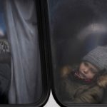 
              Two children, traveling with others fleeing Ukraine, look out of the window of a bus near the border crossing in Medyka, Poland, Saturday, March 5, 2022. (AP Photo/Markus Schreiber)
            