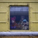 
              Children Vlada, left, Katrin and Danilo look out from a window of an unheated train carriage of an emergency evacuation train which is travelling from Kharkov to Lviv, as it stopped in the Kyiv railway station in Kyiv, Ukraine, Thursday, March 3, 2022. (AP Photo/Andriy Dubchak)
            