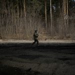 
              A Ukrainian serviceman walks on the edge of a forest in Stoyanka, Ukraine, Sunday, March 27, 2022. Ukrainian President Volodymyr Zelenskyy accused the West of lacking courage as his country fights to stave off Russia's invading troops, making an exasperated plea for fighter jets and tanks to sustain a defense in a conflict that has ground into a war of attrition. (AP Photo/Vadim Ghirda)
            