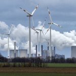 
              FILE - Renewable and fossil-fuel energy is produced when wind generators are seen in front of a coal fired power plant near Jackerath, Germany, Friday, Dec. 7, 2018. The head of the International Renewable Energy Agency says “radical action” is needed to ensure global warming doesn't pass dangerous thresholds, warning that greenhouse gas emissions are heading in the wrong direction. (AP Photo/Martin Meissner, File)
            