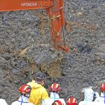 
              In this photo released by Xinhua News Agency, rescuers look on as an excavator digs into the earth at the crash site of the China Eastern 737-800 flight in Tengxian County, southern China's Guangxi Zhuang Autonomous Region on Saturday, March 26, 2022. Construction excavators dug into a crash site Saturday in the search for wreckage, remains and the second black box from a China Eastern 737-800 that nosedived into a mountainside in southern China this week with 132 people on board. (Zhou Hua/Xinhua via AP)
            