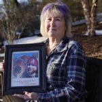 
              Lynn Wencus, of Wrentham, Mass., holds a photograph of her son Jeff at her home, in Wrentham, Wednesday, March 2, 2022. Wencus lost her son to a heroin overdose in 2017. OxyContin maker Purdue Pharma and virtually all U.S. states have agreed to a new settlement of opioid lawsuits. The deal reached Thursday, March 3, 2022, would require members of the Sackler family who own the drugmaker to pay $5.5 billion to $6 billion in cash. They also apologized. A bankruptcy judge must still approve the deal. (AP Photo/Steven Senne)
            