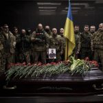 
              Ukrainian servicemen attend the funeral ceremony of marine Alexandr Khovtun, in Kyiv, Ukraine, Sunday, March 20, 2022. Khovtun died in combat in the town of Huta-Mezhyhirska, north of Kyiv. (AP Photo/Felipe Dana)
            