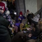 
              People sit in a basement, used as a bomb shelter, during an air raid in Lviv, Western Ukraine, Saturday, March 19, 2022. Lviv has been a refuge since the war began nearly a month ago, the last outpost before Poland and host to hundreds of thousands of Ukrainians streaming through or staying on. (AP Photo/Bernat Armangue)
            