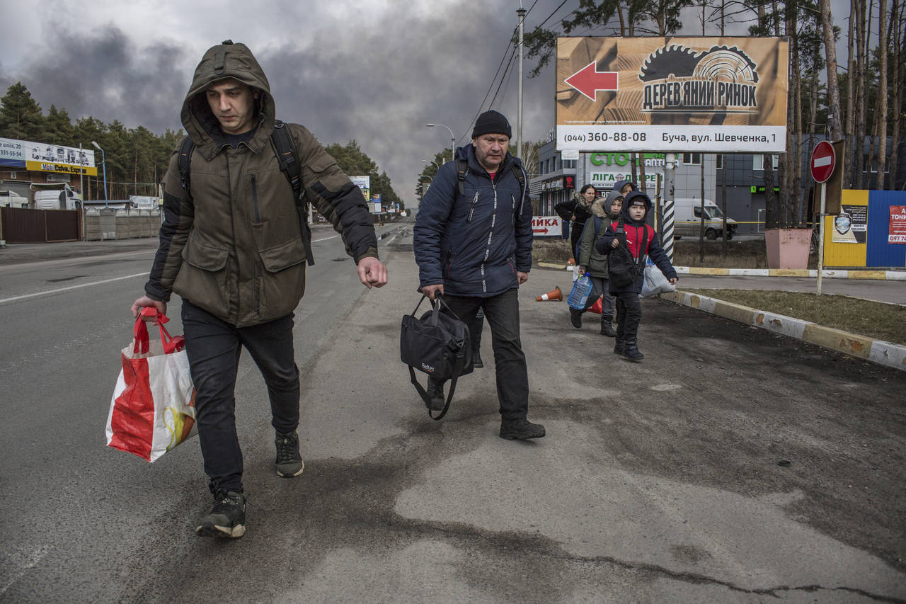 People leave the town of Bucha, close to Kyiv, Ukraine, Friday, March 4, 2022. (AP Photo/Oleksandr ...