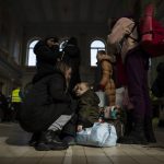 
              A Ukrainian woman Olga, 25, and her child Svatoslav, 2, who fled the war from Poltava region in Ukraine wait at Przemysl train station on their way to Germany, in Przemysl, Poland, Tuesday, March 15, 2022. (AP Photo/Petros Giannakouris)
            